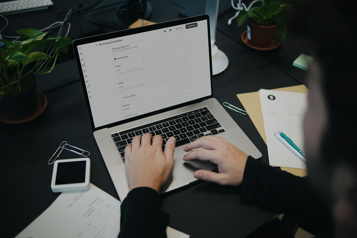 Someone editing an invoice on a laptop at a desk